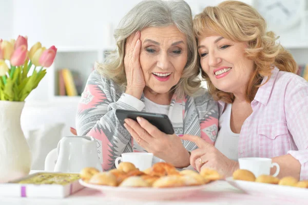 Zwei Seniorinnen Nutzen Smartphone Hause Beim Teetrinken — Stockfoto