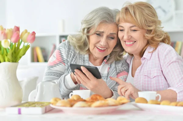 Zwei Seniorinnen Nutzen Smartphone Hause Beim Teetrinken — Stockfoto
