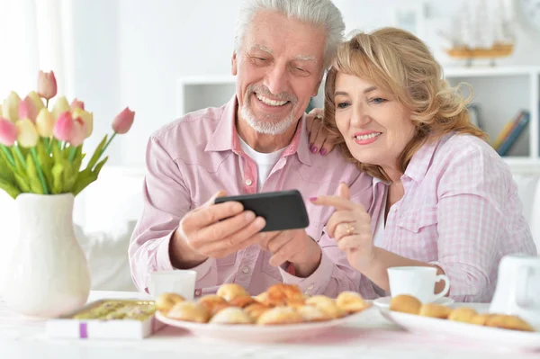 Glückliches Seniorenpaar Mit Smartphone Trinkt Tee Der Küche — Stockfoto