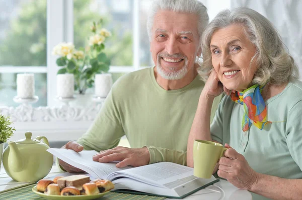 Glückliches Seniorenpaar Mit Buch Das Tee Trinkt — Stockfoto