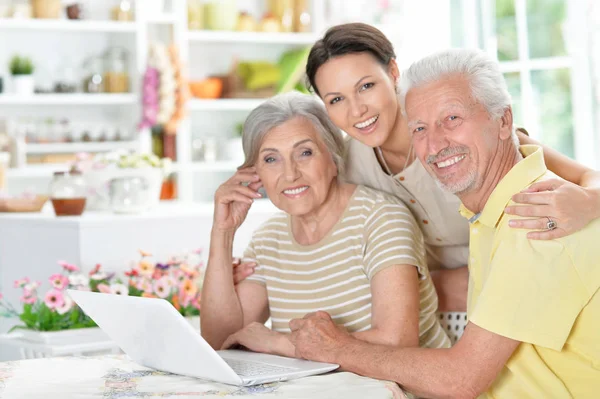 Feliz Pareja Ancianos Con Hija Adulta Utilizando Ordenador Portátil Casa —  Fotos de Stock