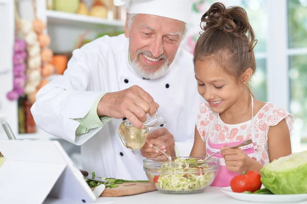 Mann bereitet Abendessen mit Enkelin vor — Stockfoto