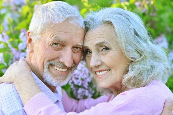 Feliz Pareja Ancianos Abrazándose Fondo Las Flores —  Fotos de Stock