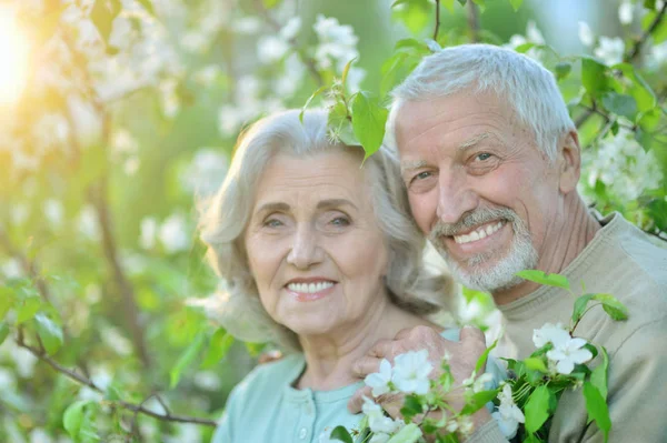 Feliz Pareja Ancianos Abrazándose Fondo Las Flores —  Fotos de Stock