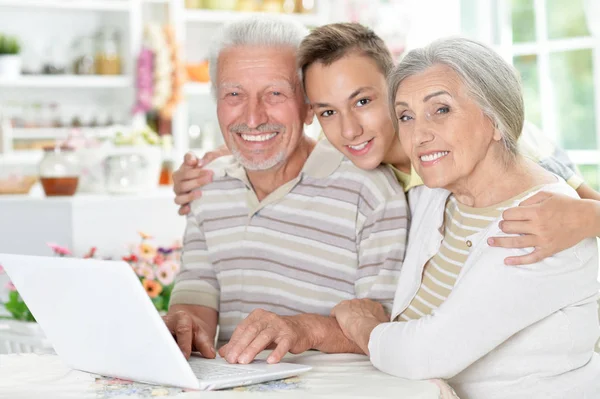 Szczęśliwa Para Starszy Wnuka Pomocą Laptopa Domu — Zdjęcie stockowe