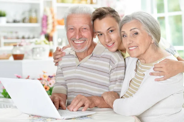 Feliz Casal Sênior Com Neto Usando Laptop Casa — Fotografia de Stock