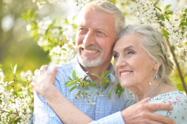 Lyckliga Äldre Par Som Kramas Blommor Bakgrund — Stockfoto