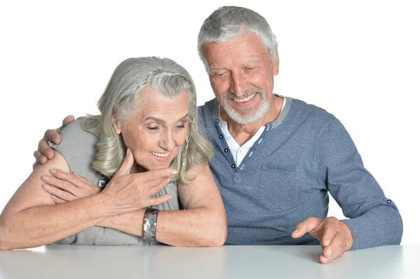 Retrato Abraçar Casal Sênior Sentado Mesa Isolado Fundo Branco — Fotografia de Stock