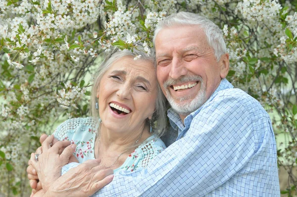 Feliz Pareja Ancianos Abrazándose Fondo Las Flores —  Fotos de Stock