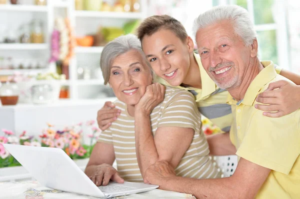 Feliz Casal Sênior Com Neto Usando Laptop Casa — Fotografia de Stock