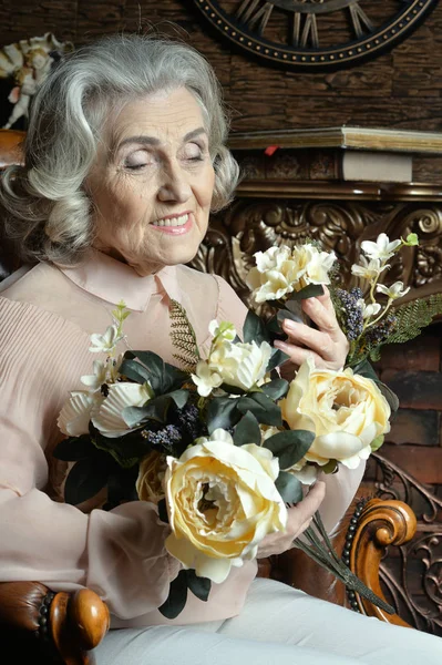自宅の花と年配の女性の肖像画 — ストック写真