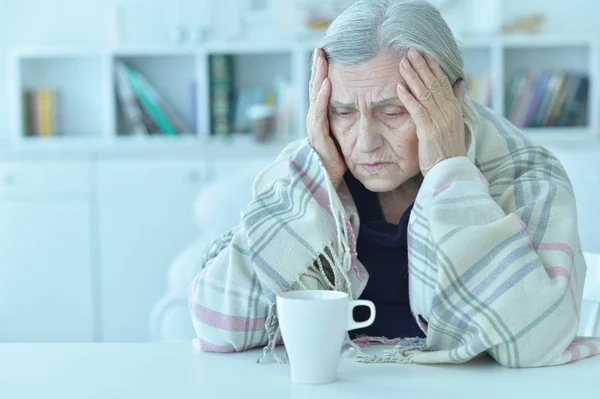 一个悲伤的老妇人的画像与头疼喝茶 — 图库照片