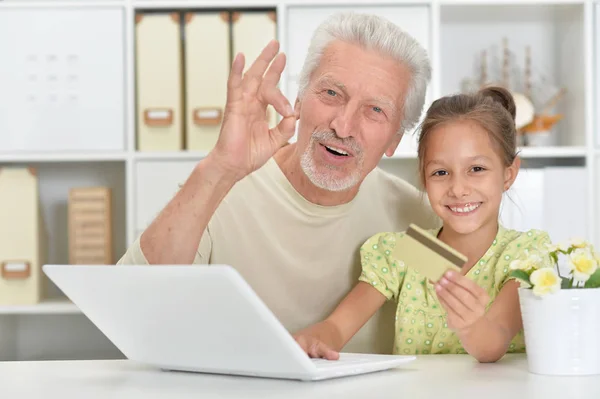 Retrato Menina Avô Com Laptop Casa Menina Segurando Cartão Crédito — Fotografia de Stock