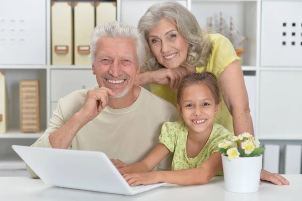 Großeltern Mit Ihrer Enkelin Mit Laptop Hause — Stockfoto