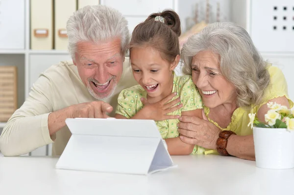 祖父母与她的孙女在家里使用片剂 — 图库照片