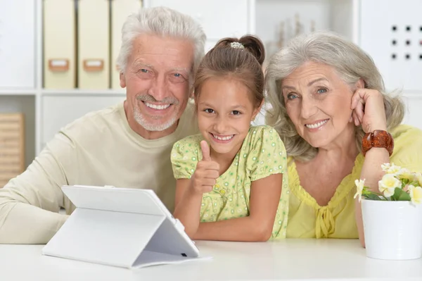 Dziadkowie Jej Wnuczka Domu Pomocą Tabletu — Zdjęcie stockowe