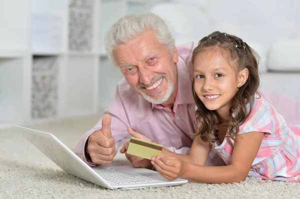 家庭用笔记本电脑和信用卡的女孩和祖父肖像 — 图库照片