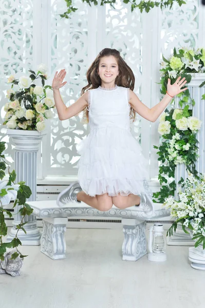 快乐的小女孩在白色礼服跳跃 — 图库照片
