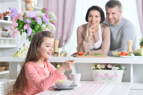 Leende Flicka Äter Köket Med Föräldrar Bakgrunden — Stockfoto