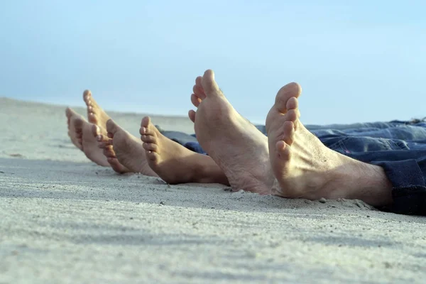 Piedi Quattro Persone Distesi Sabbia Chiara — Foto Stock