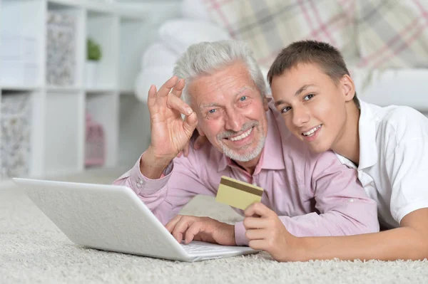 Dziadek Wnuk Leżącego Podłodze Przy Użyciu Laptopa Wnuk Gospodarstwa Karta — Zdjęcie stockowe