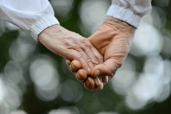Äldre par som håller varandra i handen — Stockfoto