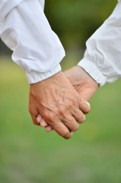 Пожилая пара держится за руки — стоковое фото