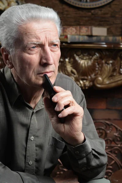 Porträtt Tankeväckande Senior Man Med Smartphone Hemma — Stockfoto