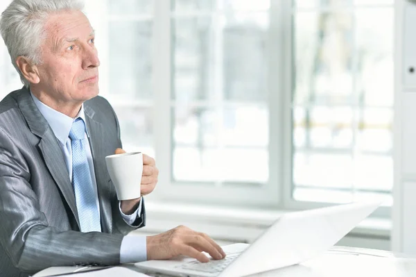 Senior man met laptop — Stockfoto