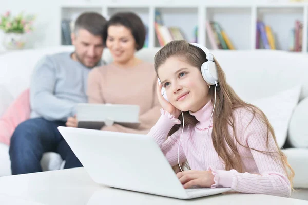 Menina Feliz Sentada Mesa Com Laptop Com Seus Pais Fundo — Fotografia de Stock