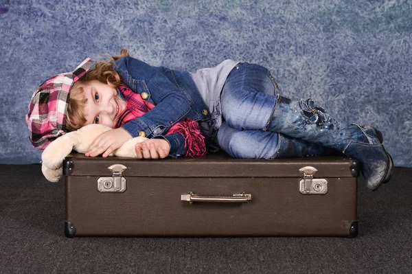 Glückliches Kleines Mädchen Mit Spielzeug Auf Koffer Liegend — Stockfoto