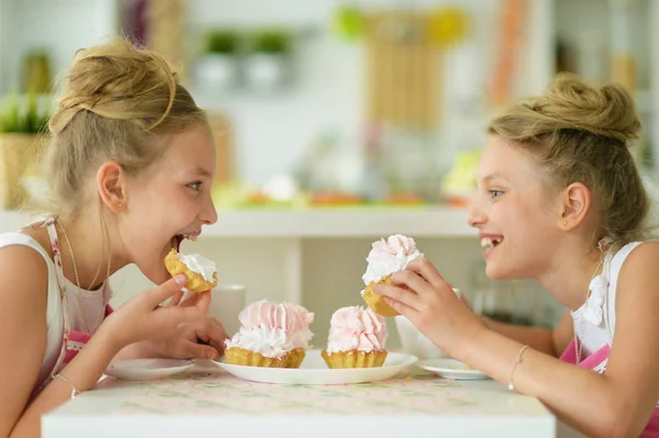 Sestry-dvojčata jíst chutné koláčky — Stock fotografie