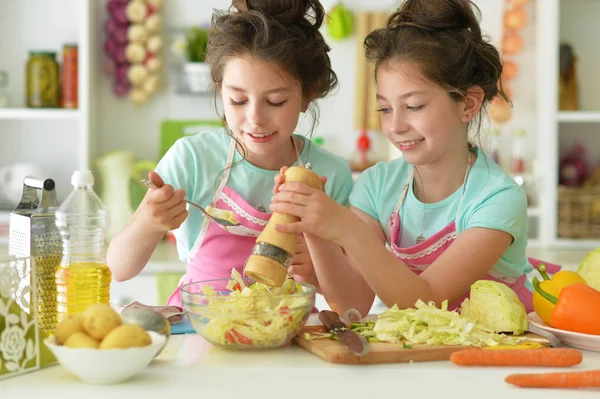 Twin sisters cooking in kitchen — стоковое фото