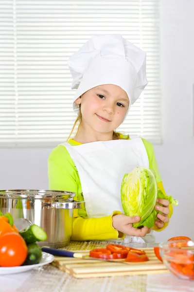 穿着厨师制服的女孩在厨房里做饭 — 图库照片