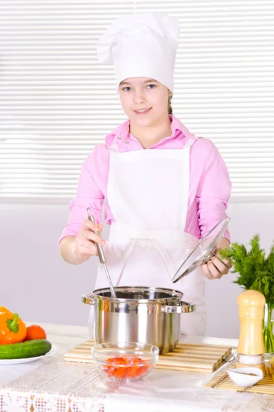 美丽的女孩穿着厨师均匀烹调厨房 — 图库照片