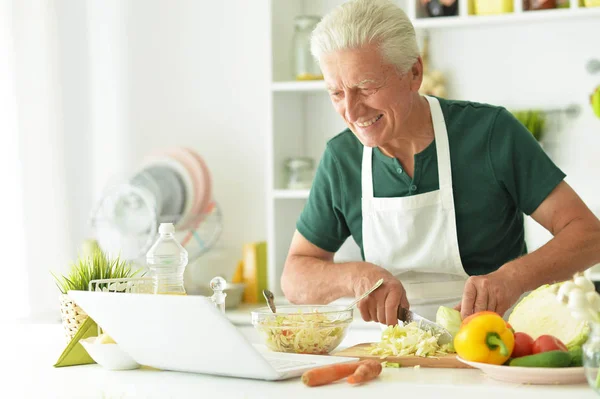 Senior man cooking in kitchen — Stock Photo, Image