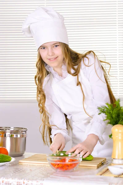 キッチンで調理するシェフの制服を着て美しい少女 — ストック写真
