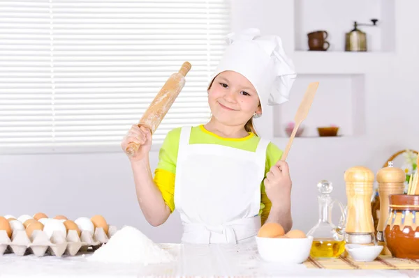 Cute girl baking cake in the kitchen at home