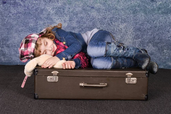 Glückliches Kleines Mädchen Mit Spielzeug Auf Koffer Liegend — Stockfoto