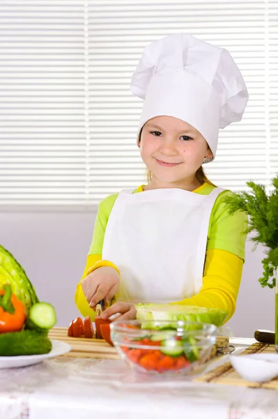 女孩穿着厨师制服在厨房切菜 — 图库照片