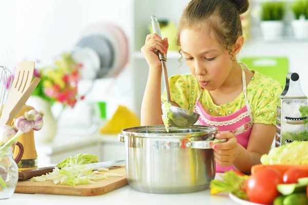 Маленькая девочка пробует суп — стоковое фото