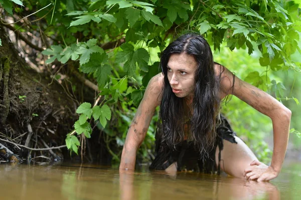 黒い服が川でポーズで野生の若い女性 — ストック写真