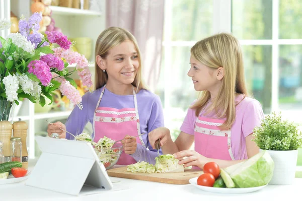 Två Flickor Förkläden Förbereder Fräsch Sallad Köksbordet Med Tablett — Stockfoto