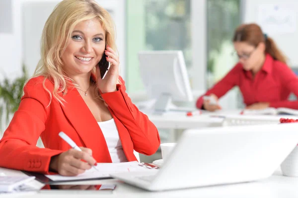 近代的なオフィスで働く赤ジャケットの美しい金髪女性実業家 — ストック写真