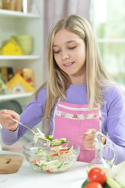 タブレットを自宅の台所のテーブルに新鮮なサラダを準備するかわいい女の子 — ストック写真