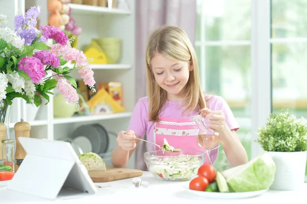 可爱的小女孩在厨房桌上准备新鲜沙拉与片剂在家 — 图库照片