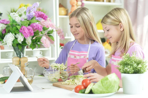 Two Girls Aprons Preparing Fresh Salad Kitchen Table Tablet — Stock Photo, Image