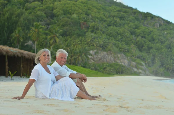 幸福的老年夫妇坐在热带海滩上 — 图库照片