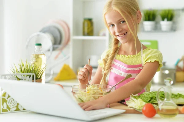 Menina na cozinha com laptop — Fotografia de Stock