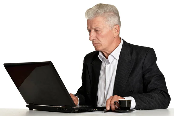在白色背景下使用笔记本电脑的老商人 — 图库照片